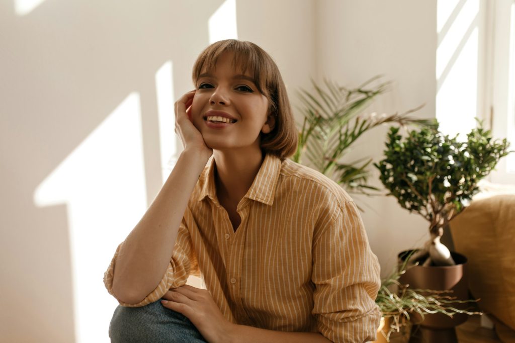 a woman smiling with her hand on her face
