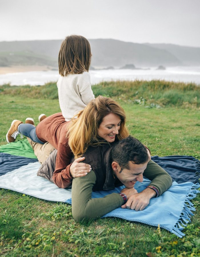 Happy family on blanket at the coast